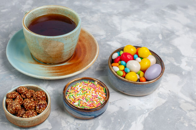 饮料在浅白的桌子上 可以看到一杯茶和五颜六色的糖果糖盘子食物
