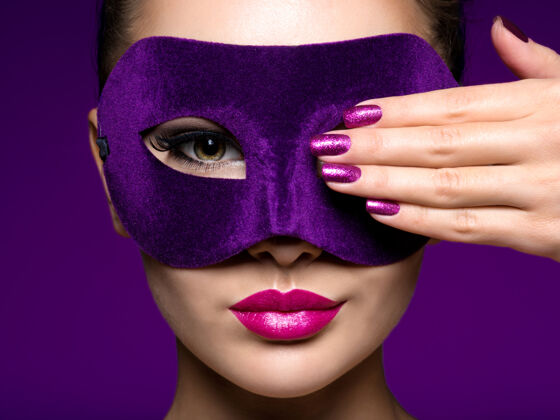 唇膏一个漂亮女人的肖像 紫色的指甲 脸上戴着紫色的戏剧面具戏剧指甲肖像