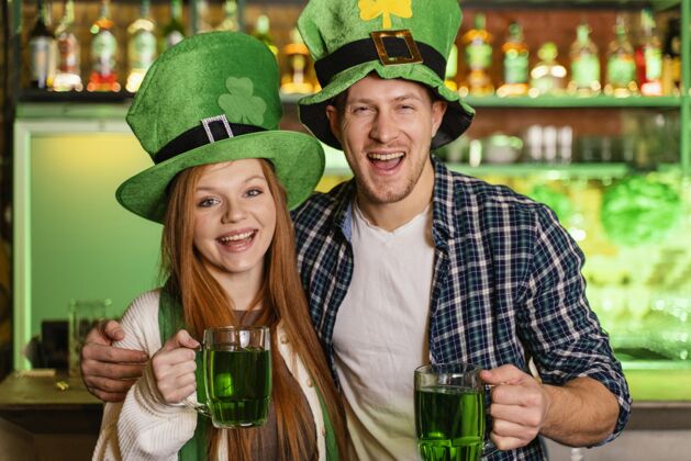 3月17日笑脸男男女女在酒吧庆祝圣帕特里克节帽子饮料男人