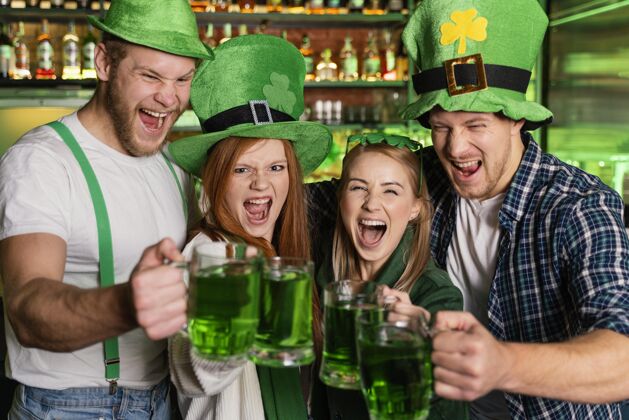 女性微笑的人们在酒吧庆祝圣帕特里克节帽子男性三叶草