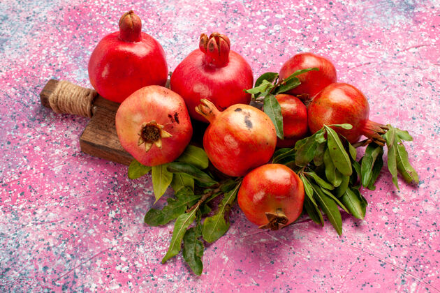 农产品正面是新鲜的红色石榴 粉红色的表面有绿叶健的食品