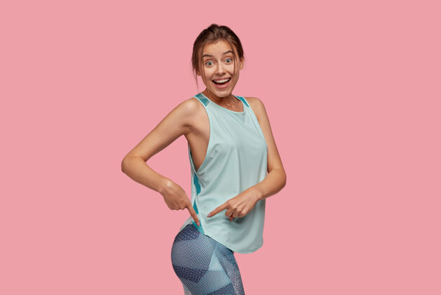 运动高兴的女人指着屁股的照片指示器动机形状