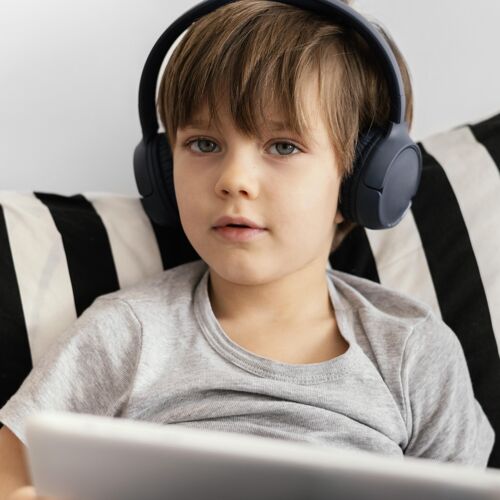 现代特写戴着耳机的孩子平板电脑设备娱乐