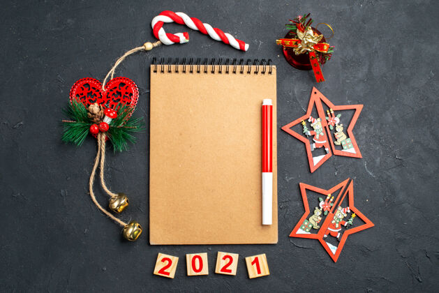 扣子顶视图笔记本上的红色标记站在一个不同的圣诞节装饰圈在黑暗孤立的表面新年照片顶部视图圆圈