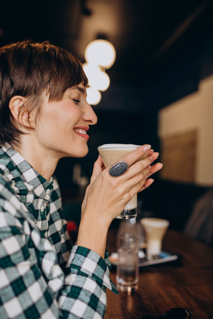 快乐的女人在咖啡馆喝拿铁的法国女人咖啡肖像温暖