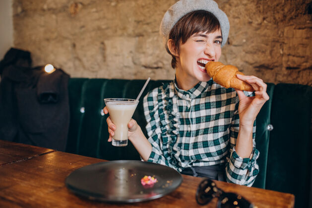 人在咖啡馆喝拿铁吃羊角面包的法国女人法国女性美味