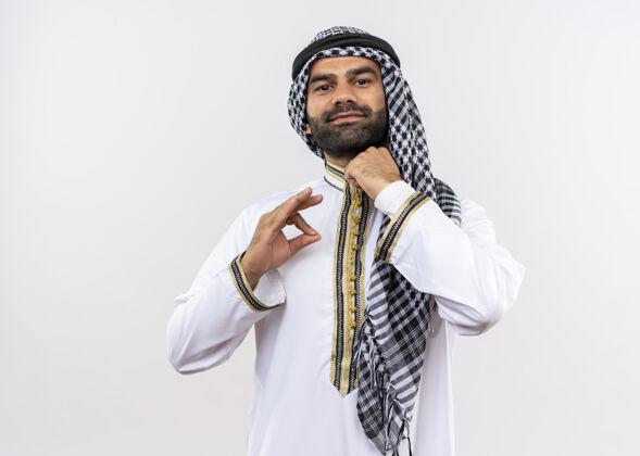 领一个穿着传统服装的阿拉伯男人站在白墙上 看起来很自信阿拉伯语男人看