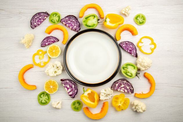 食物俯瞰白色的木桌上的白色盘子切蔬菜早餐碗混合饮料