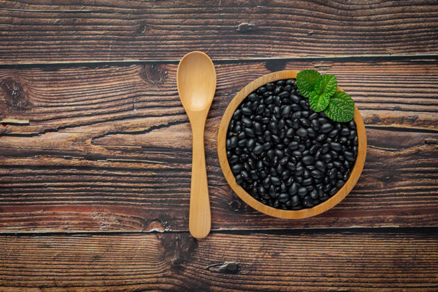 排毒黑豆在小木盘上放在木地板上草药作物丰富