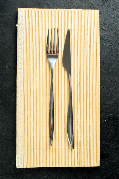 勺子黑色桌子上米色木板上的顶视图刀叉叉子梳子视图