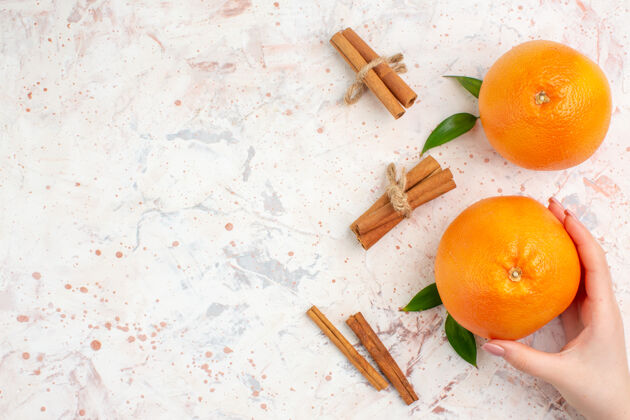 景观顶视图新鲜的橘子肉桂棒橘子在女性手上明亮的表面和复制的地方明亮多汁脐橙