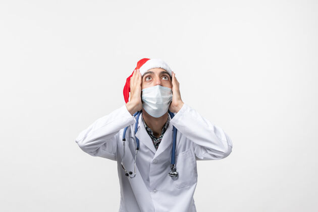 大流行正面图白色地板上戴口罩的男医生假日病毒大流行圣诞节医生男医生