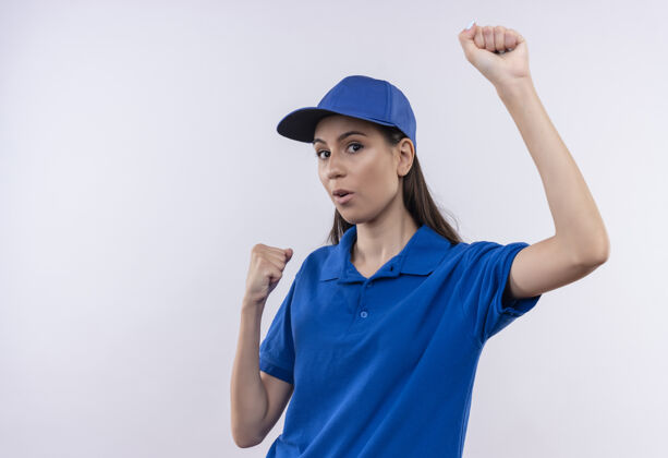 制服身穿蓝色制服 头戴鸭舌帽的年轻送货女孩高兴地伸出紧握的拳头快乐蓝色拳头