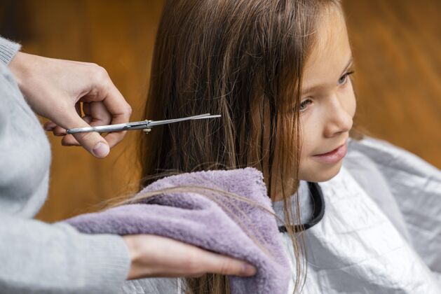 沙龙理发师剪小女孩的头发发型发型师理发师