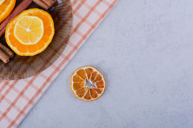 成熟把橘子片和柠檬片放在玻璃碗里 放上肉桂条调味品美味柑橘