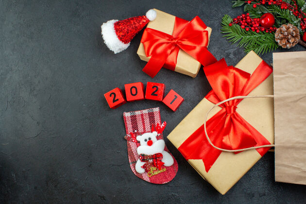 袜子上图：在黑暗的背景下 圣诞气氛与红色丝带和数字圣诞老人帽子xsmas袜子美丽的礼物圣诞老人心情轮子