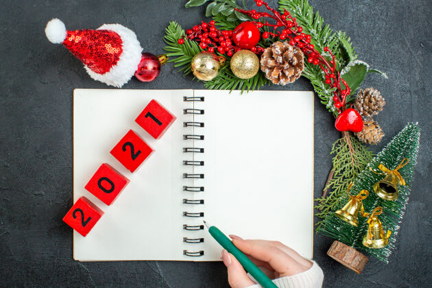 信封上图是圣诞心情与杉木树枝圣诞老人帽子圣诞树上笔记本的数字在黑暗的背景号码圣诞老人帽子