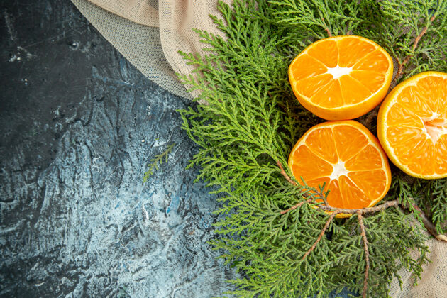 柑橘俯视图切橘子米色披肩在黑暗的表面切片视图维生素
