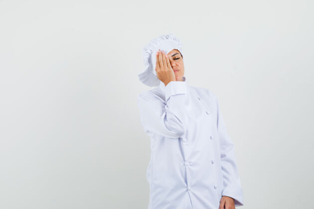 工业一位身穿白色制服的女厨师手把手放在脸上 看起来很困亚洲举行烹饪