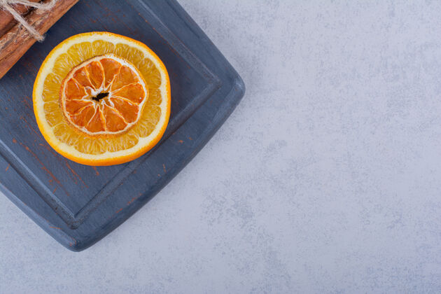 调味品橘子片放在深色的木板上 配上香浓的肉桂条肉桂健康水果