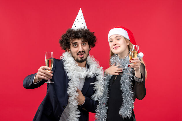 年轻夫妇前视图年轻夫妇庆祝新年在红墙圣诞爱情假期成人服装圣诞节