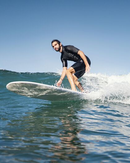 海滩他骑着冲浪板玩得很开心冒险冲浪者异国情调