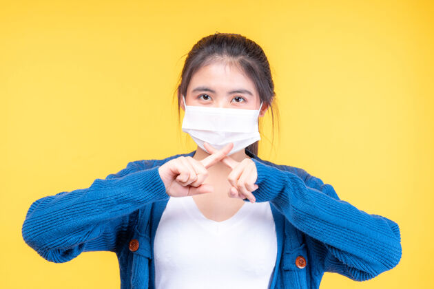 病毒传播戴着口罩的亚洲女孩展示停止双手的手势 以阻止电晕病毒的爆发隔离室14天防护