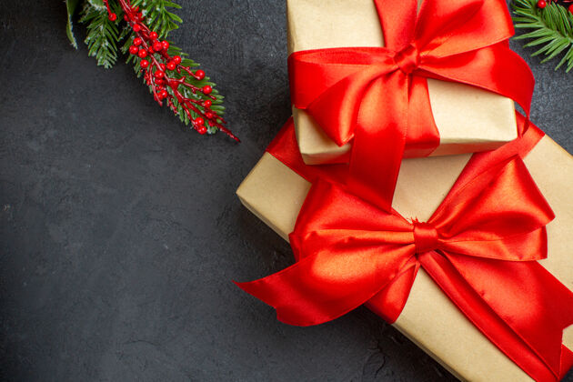 圣诞节圣诞背景与美丽的礼物与蝴蝶结形丝带和冷杉枝在一个黑暗的桌子上蝴蝶结蝴蝶结树枝