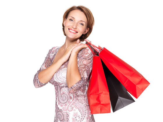 女性带着购物袋在白墙上微笑的女人成人购物狂漂亮