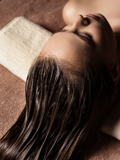 健康正在spa沙龙接受头发护理程序的年轻女士美容spa沙龙放松闭上眼睛治疗
