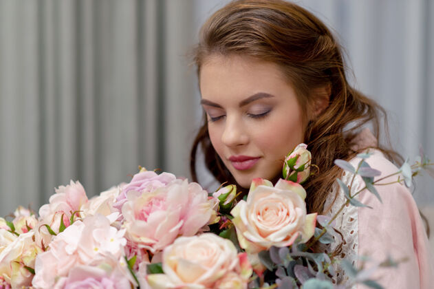 室内一个漂亮的年轻女子 手里拿着成百上千束鲜花 正待在家里呢吸引力女孩花