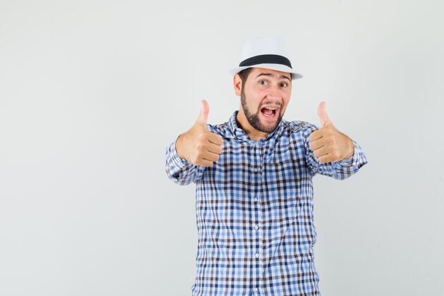 男士年轻男性穿着格子衬衫 戴着帽子 向上竖起大拇指 看上去很开心正面图表情拇指自信