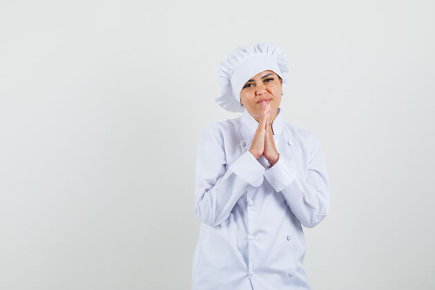 制服身穿白色制服的女厨师手牵手祈祷 看上去充满希望工作烹饪烹饪