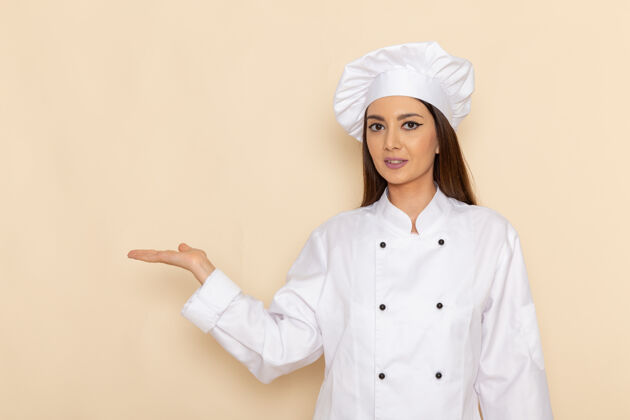 服装身穿白色厨师服的年轻女厨师在浅白的墙上举手摆姿势的正面图手工作西装