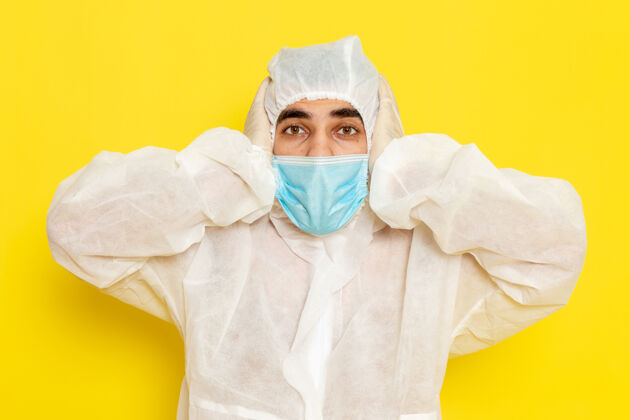 面罩身穿白色特殊防护服 戴着浅黄色面罩的男性科学工作者的正面图科学危险化学