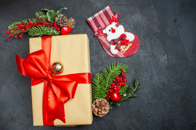 圣诞圣诞背景与蝴蝶结形丝带和杉木枝装饰配件圣诞袜子上一个黑暗的表v美丽的礼物一块布袜子冷杉