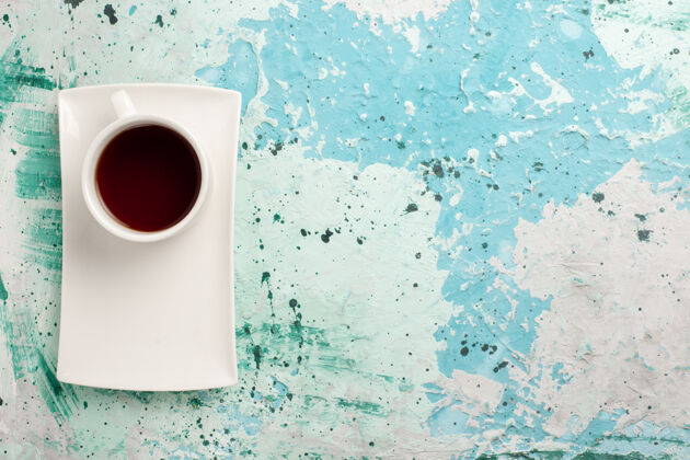 盘子顶视图茶杯内部茶杯和浅蓝表面的盘子液体饮料生的