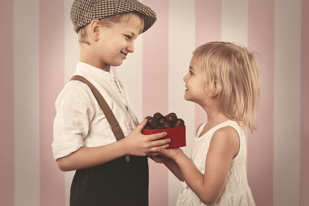 小男孩给女孩一盒巧克力约会姿势牙齿