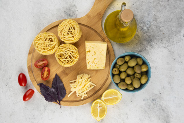 干的意大利面 蔬菜和奶酪放在木板上 配橄榄生的通心粉顶部视图