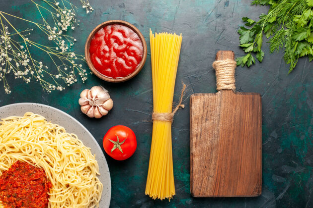 刷子蓝色桌子上的番茄酱肉末意大利面俯瞰图烹饪顶部面团