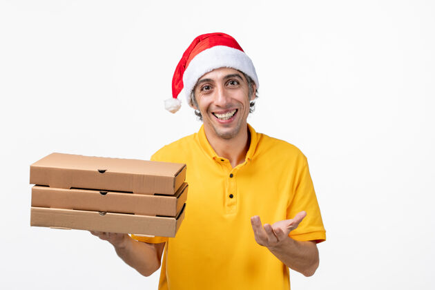 送货正面图：男快递员用披萨盒在白墙上统一送货盒子视图建筑商