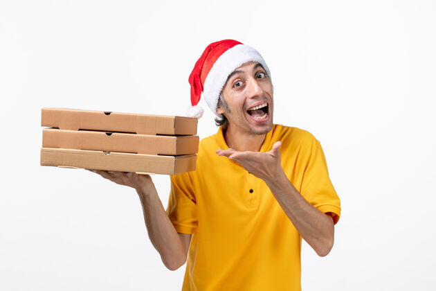圣诞节正面图男快递员用披萨盒在白墙上统一送货服务修理工工人男信使