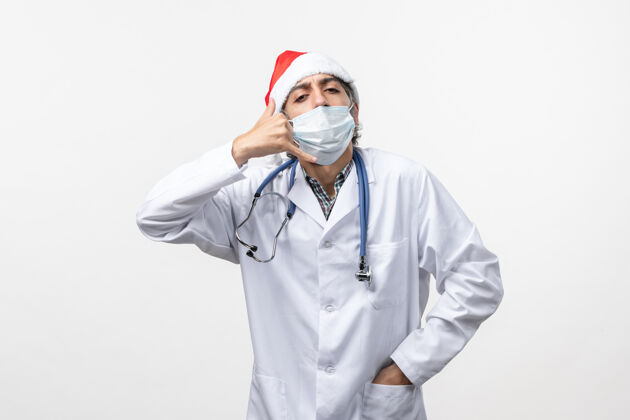 男人正面图白色墙壁上戴着口罩的男医生可维假日大流行病毒服装病毒冠状病毒