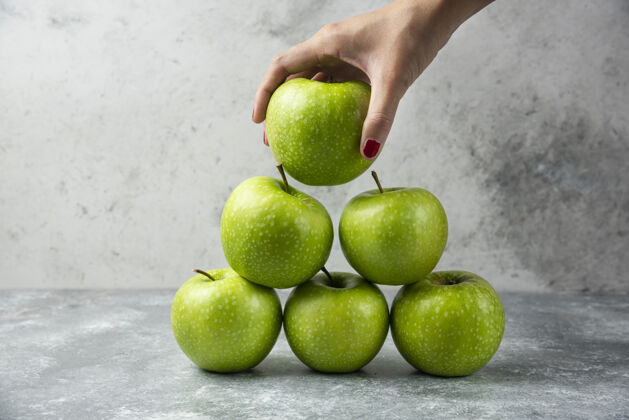 食物女人手里拿着许多苹果中的一个绿色有机美味