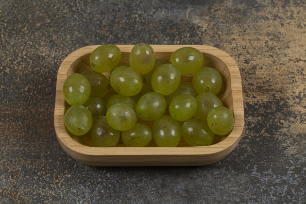 一串一堆绿色的葡萄放在木碗上新鲜成熟浆果