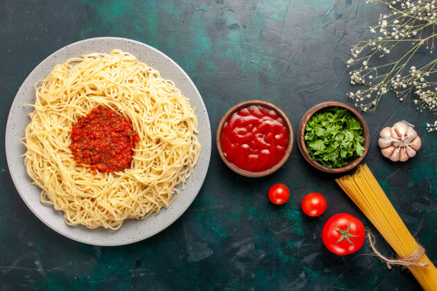 食物俯瞰意大利面 蓝色表面有肉末 番茄酱和调味料面食西红柿晚餐