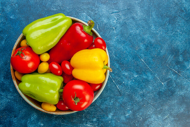 餐桌顶视图蔬菜不同颜色的甜椒西红柿樱桃西红柿在碗里蓝色的桌子上复制的地方甜椒健康碗