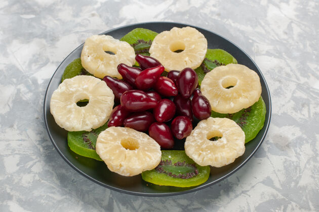 酸正面图：干果 菠萝环和白色表面的猕猴桃片餐饮食干