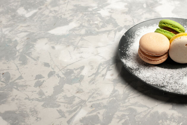 蛋糕前视图法国麦卡龙美味的彩色蛋糕内板上的白色表面前面法式冰