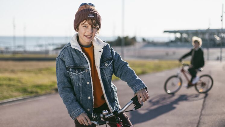 休闲当他的朋友骑自行车时 男孩摆姿势活跃儿童水平